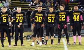 Referee Mike Bullen leads Meeker High School senior captains Nate Walsh, J.R. Crawford, Fernando Olivas, (Austin Brown behind Olivas) Adrian Shoyer, Alex Smith, Tala Atoafa and Scott Smith, out for the coin flip before the 2012 homecoming game against the Paonia Eagles. The grandstands at Starbuck Stadium later cheered on the Cowboys in an exciting game they fought hard to win, yet lost by one point. Meeker will play in Cedaredge this Friday.