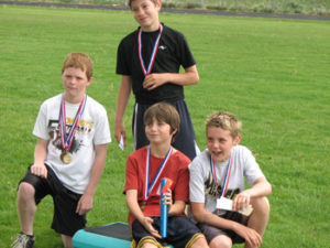 Members of the boys’ 4x100 relay team in the 11-12 age group received medals for their winning effort. From left, Jacob Phelan, Jake Nielsen (standing), Sam Nieslanik and Jacob Henderson. 