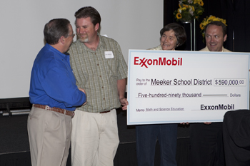 Jason Hightower, second from left, principal of Meeker Elementary School, is congratulated by ExxonMobil executive Jim Branch after the presentation of a $590,000 gift to the Meeker School District.