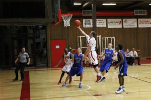 CNCC sophomore guard Thomas Powers, this year’s second highest scorer in the Scenic West Athletic Conference (SWAC), drives to the basket against Salt Lake Community College defenders. Despite losing several players early in the season, the Spartans played competitively at the SWAC Region 18 tournament Feb. 28,  losing narrowly to Snow College.