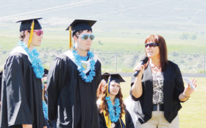 Teacher Becca Nielsen, the commencement speaker at the Meeker High School Class of 2013 graduation festivities at Starbuck Stadium, had fun with graduating twins Scott and Alex Smith during her speech, teasing the brothers about how tough it has been to tell them apart. 
