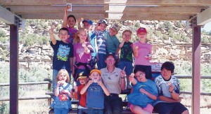 The 2013 Junior Rangers class from the College for Kids in Rangely, led by Ranger Jennifer Walgrave, center, show off new patches at the East Four Mile Draw Site in the Canyon Pintado National Historic District.
