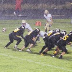 Cowboy quarterback Jake Phelan prepares to receive a snap in the snow during the game against the Lake County Panthers, which Meeker won 46-0. Phelan led the team with 111 yards rushing, 66 passing and an interception on defense.