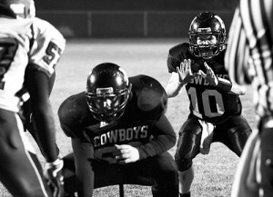 Cowboy quarterback Jake Phelan prepares to receive a snap from center Kash Atwood against the defending state champion Cedaredge Bruins. Phelan scored three rushing touchdowns, passed for another, and made three 2-point conversions but it was not enough, as the Cowboys lost 38-30.