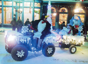 Ron Spencer, disguised as a penguin, drives the Ma Famiglia Italian Restaurant float on Friday night in the Meeker Parade of Lights. Not to be forgotten are passengers Sage Jensen and Shailee Rundberg, back right end of the float.