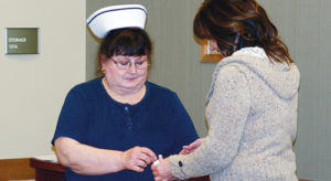 Registered nurse Anne Benhart, left, prepares to pin Ruth King’s granddaughter, Jennifer Turner, with the Ruth King Excellence in Nursing Award. King, former nursing director Mary Reese and longtime Rangely District Hospital nurse Sheryl Sheley were the first recipients of the award — King and Reese posthumously. Chief nursing officer Sharma Vaughn said that King, a registered nurse who worked for Rangely Community Hospital and RDH in their fledgling years and for decades afterward, passed on a legacy of professionalism and care to generations of RDH nursing staff.