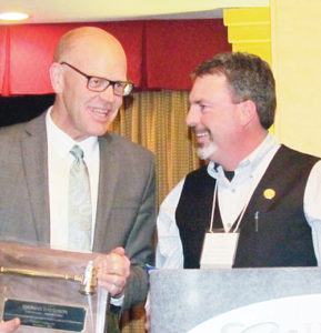 Thomas Davidson, left, president of Colorado Counties Inc. (CCI) and a county commissioner from Summit County, hands the group presidency over to Rio Blanco County Commissioner Shawn Bolton, right, at the group’s December meeting. CCI consists of 62 of the state’s 64 counties. Bolton will serve as CCI board president during 2014.