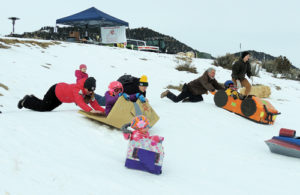 A group of racers in their cardboard sleds get  a push at the starting line on Saturday morning at Paintbrush Park as part of the events Friday and Saturday sponsored by the ERBM Recreation and Park District. There were several classifications of racers during the event.