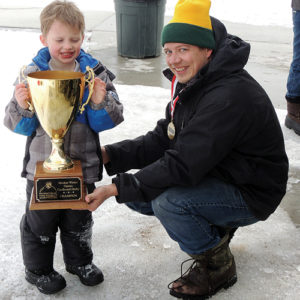 The overall winner of the race event at Paintbrush Park on Saturday was Xavier Buisker, left, who is assisted in holding his winning trophy by his father, Adam. The entire Buisker family participated, and Xavier’s sister, Lilly, won a ribbon as well. As soon as the races were over, free hot dogs and hamburgers were served to the participants by Bobby Gutierrez of Wendll’s/Cuppa Joe.