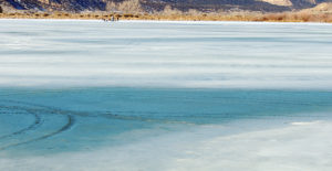 Weather on Sunday continued to be sunny and warm, causing the ice to thin even more on Rio Blanco Lake, located 18 miles west of Meeker along Highway 64 on the way to Rangely. Despite a small group of folks who were enjoying their day fishing (very top center left), the ice on most of the lake was much too thin and unsafe to drive a snow machine on.