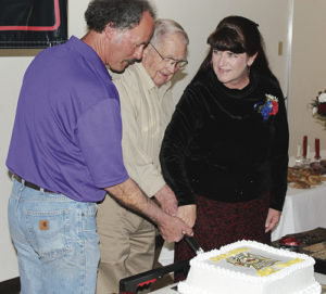 At the Meeker Volunteer Fire and Rescue Banquet on Saturday night at the Fairfield Center in Meeker, a cake-cutting ceremony was held for the oldest and newest members of the department. Dale Frisby, center, and Francis Sullivan (not pictured) are the longest-standing members with the same starting date, and Mark Rogers, left, and Carrie Cook are the newest members, starting in 2015.
