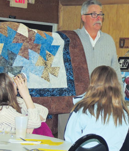 Meeker School Board Member Tom Allen displays a quilt being auctioned Sunday night at the inaugural Meeker Education Foundation dinner in Meeker. Roughly 100 persons took part in the dinner and auction, used to raise funds for Meeker student and staff awards, enrichment opportunities and classroom needs. As of Tuesday, MEF President Mary Strang said the proceeds had not all been totaled.