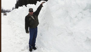 Amid a driving blizzard on the afternoon of May 20, Scott Nielsen, the Meeker district supervisor for the Rio Blanco County Road and Bridge Department, shows the depth of the snow still remaining about 200 yards from the summit of Ripple Creek Pass, which is a couple of miles past Ripple Creek Lodge and the turnoff to Trappers Lake. The county crew has opened a pathway through the mountains on the road that goes on into the town of Yampa, in Routt County. But while the route has been cut through to the other side, travel will not be easy until there is more of a thaw, and four-wheel drive vehicles are a necessity.