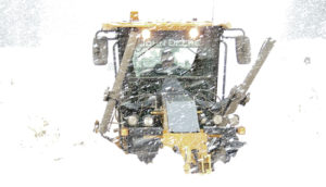 This snow plow, moving forward to clear the road, is up to its windshield in snow it is pushing. Along with the blizzard going on atop Ripple Creek Pass at the time, it is just as tough to see the snow plows from in front, amid the seven- to eight-foot snow piles on the road.
