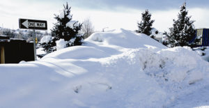 The “one way” sign is at least eight feet tall, the pine tree next to it is about 13 feet high and the trees behind the snow bank are at least 20 feet tall, yet they are buried in a snow bank in the alley that runs between Fifth and Sixth streets and Main and Market streets as the snow fell quite heavily on Tuesday morning. Between Sunday afternoon and Tuesday morning, more than a foot had fallen, and there is a shortage of places to move and dump the excess snow.
