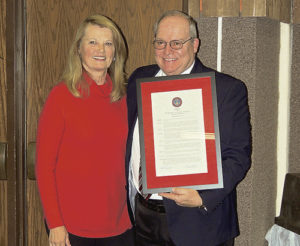 Peggy Rector, left, long a staunch supporter and active board member at Colorado Northwestern Community College, presents CNCC President Russell George with a plaque of appreciation for all the good that Russell has done for the college since he began service as president in 2011. George has announced that he will be retiring before the year is out.