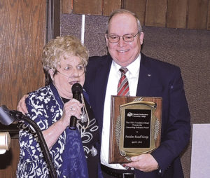 Peggy Rector, left, long a staunch supporter and active board member at Colorado Northwestern Community College, presents CNCC President Russell George with a plaque of appreciation for all the good that Russell has done for the college since he began service as president in 2011. George has announced that he will be retiring before the year is out.