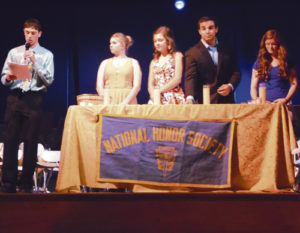 Meeker High School Scholastia Chapter National Honor Society President Nick Burri leads the induction of 17 new students as NHS members. He is assisted here in the opening ceremony, by Vice President Maggie Phelan and members Meghan Smith, Madeline Amack and T.J. Shelton.