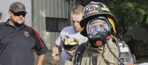 Members of the Rangely Fire and Rescue Department gave a series of demonstrations recently regarding departmental operations. Above, a couple of firemen demonstrated their working outfit by getting Luis Quintana to dress in full gear.